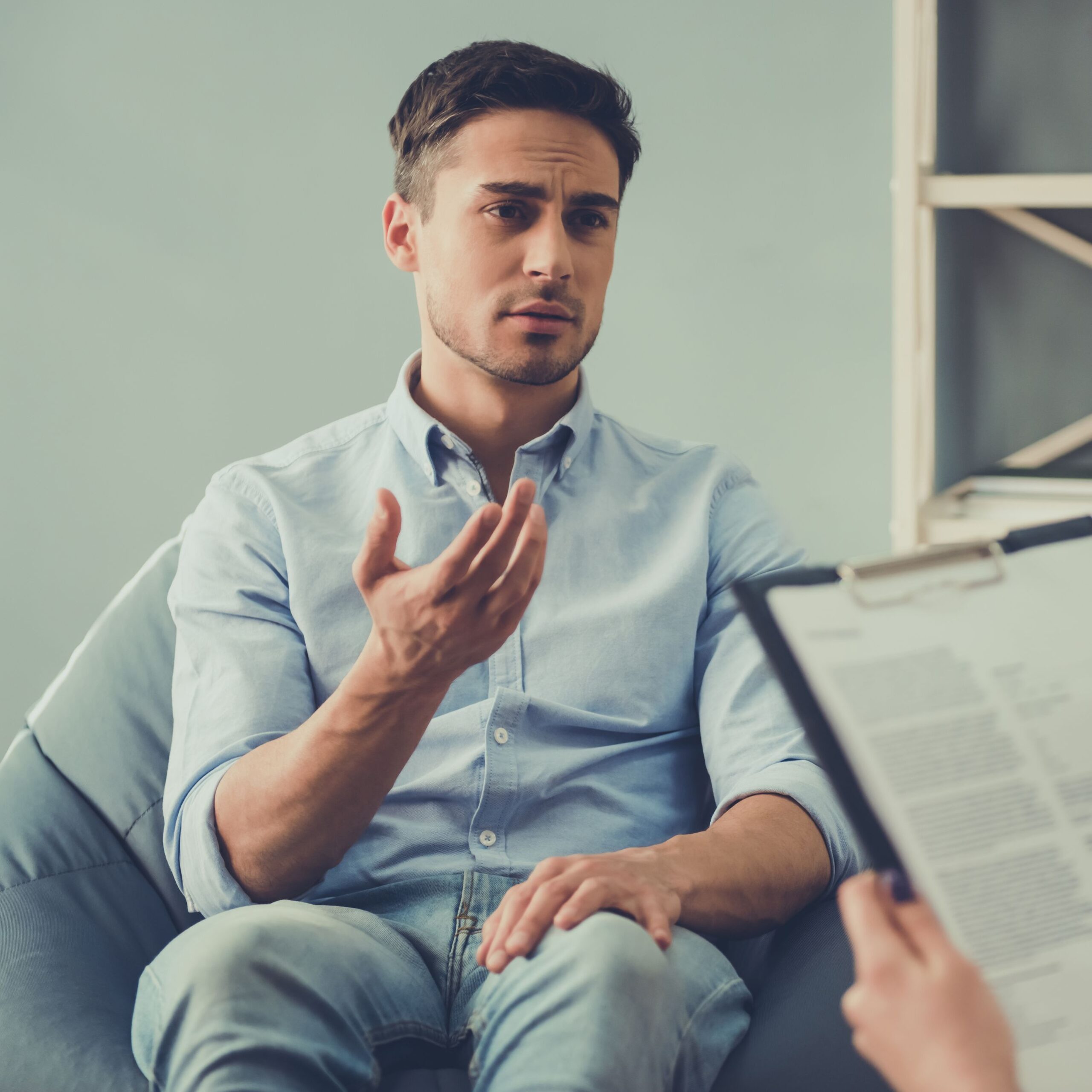 young male professional speaking to a therapist at a mental wellness facility