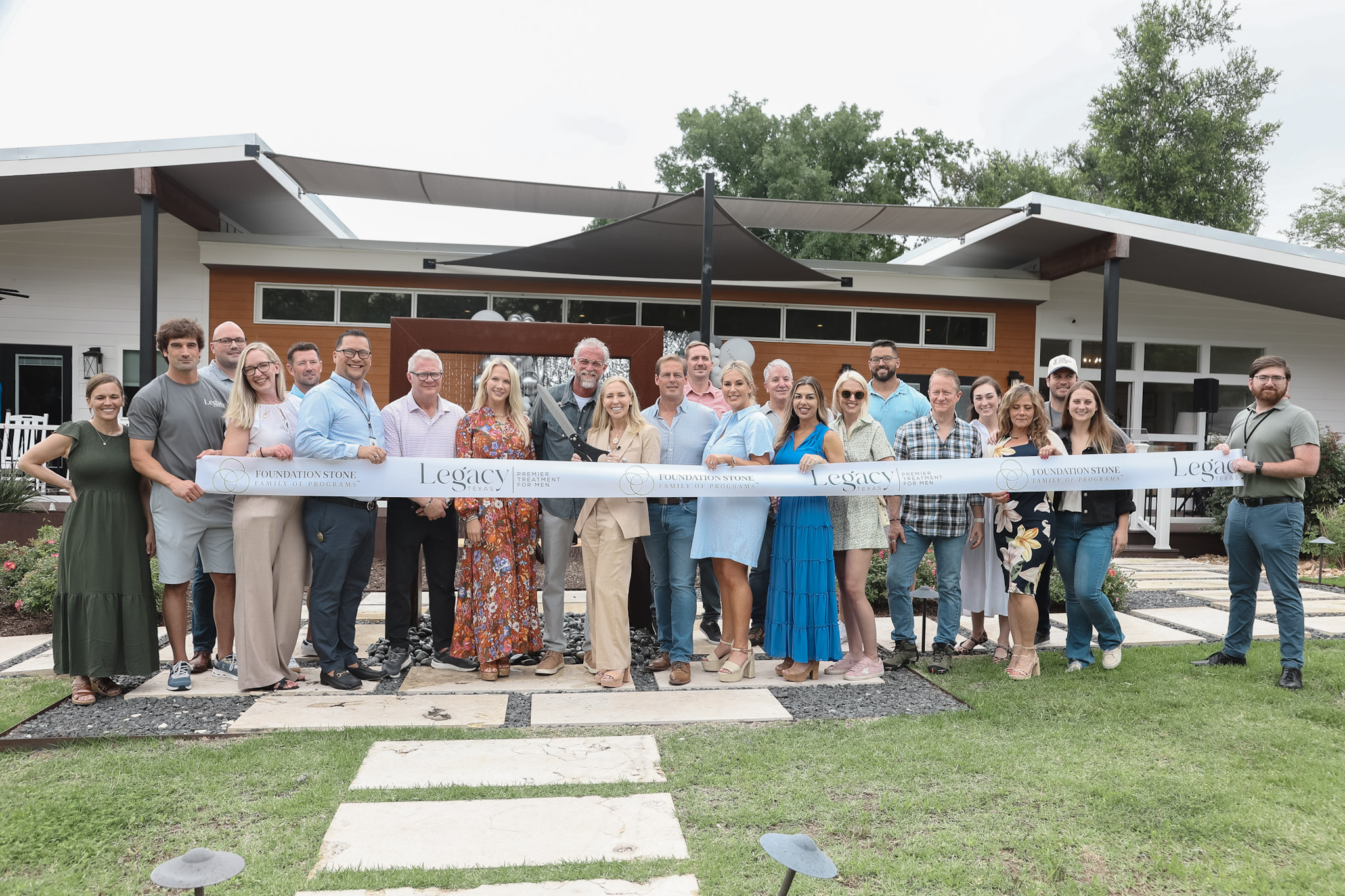 Legacy Texas team members cutting ribbon outside substance abuse and mental wellness facility